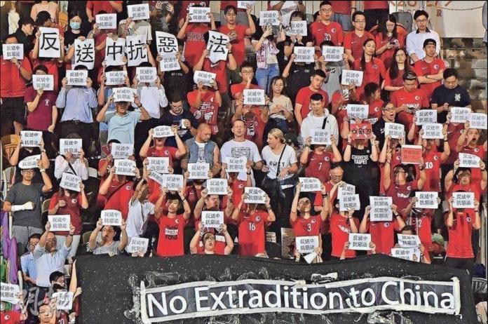 ▲國際足球邀請賽，香港球迷在場中高舉反送中標語。（圖／截自臉書）