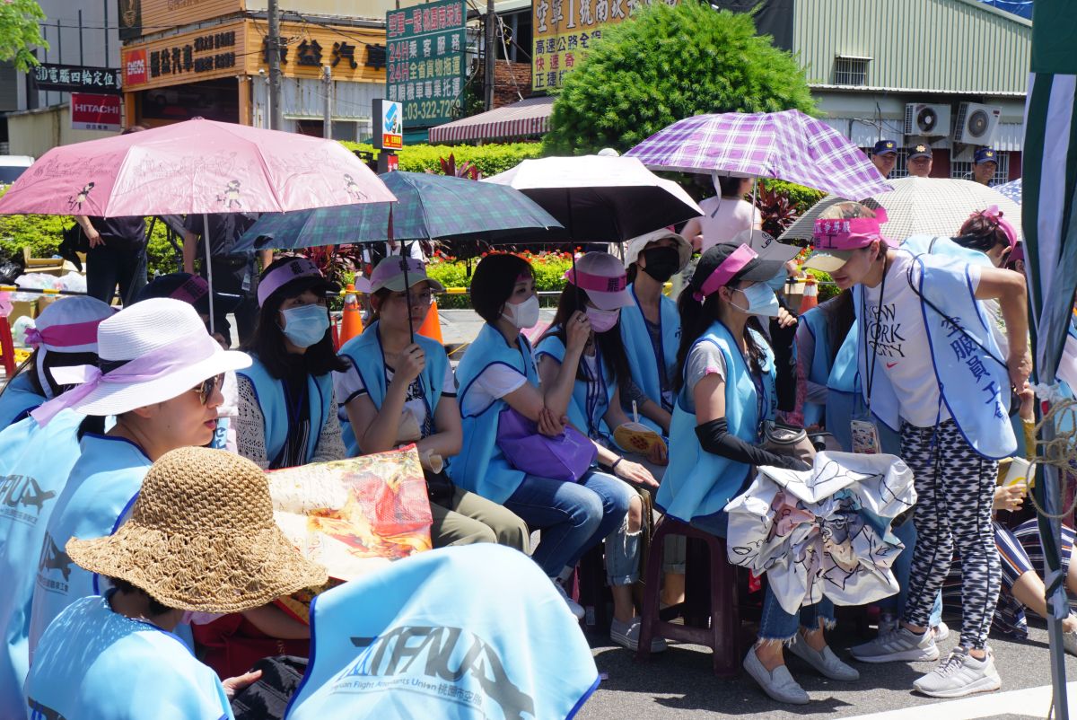 ▲長榮航空罷工邁入第二天，現場氣溫超過30度，罷工空服員稱撐起雨傘躲避艷陽。（圖／記者呂炯昌攝, 2019.6.21）