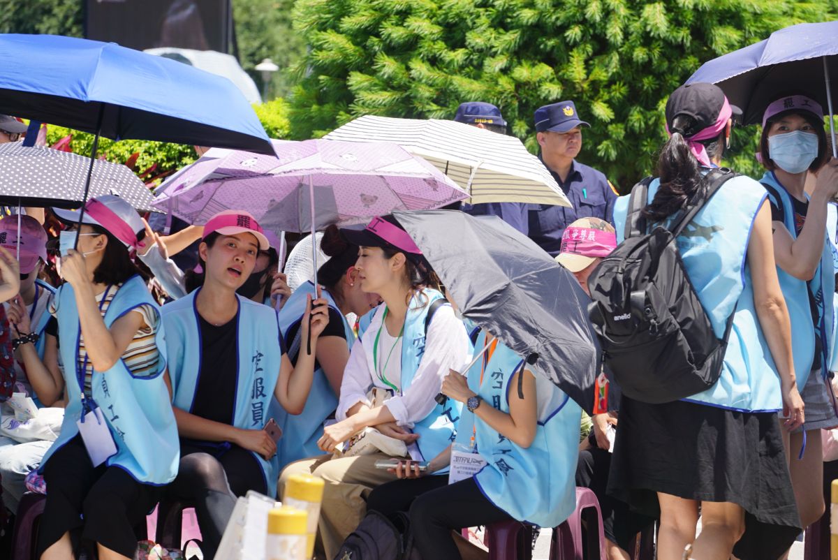 長榮航空空服員在桃園長榮航空公司前集結，發動罷工，並收取護照、工作證、台胞證等「三寶」，現場溫度高達30多度，空服員撐著陽傘遮陽。（圖／記者呂炯昌攝影.2019.6.21）