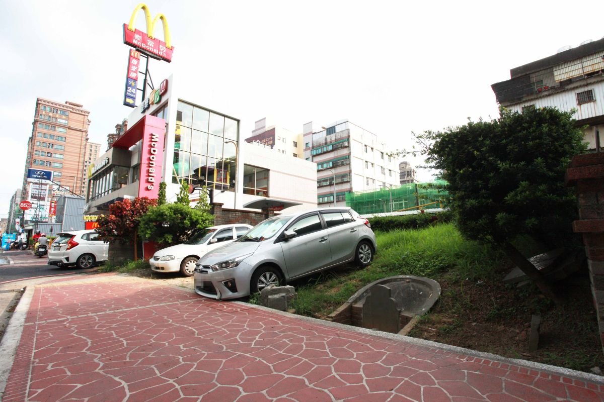 ▲桃園市桃園區經國路商圈平時人潮眾多商業活動興盛，在附近麥當勞旁的一小方綠地，走近了才知道是一處墓園，上面還有好幾座的墳墓。（圖／記者李春台攝, 2019.07.01）