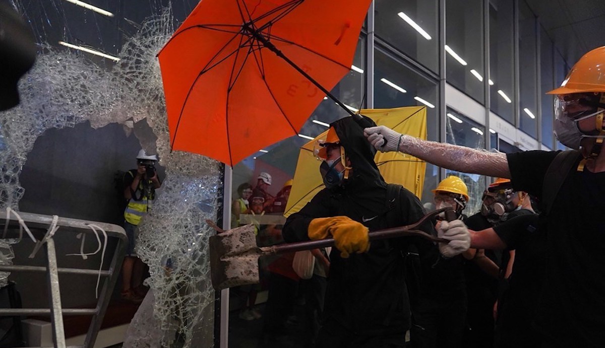 ▲反對逃犯條例修訂的香港民眾 1 日持續抗爭，示威者以工具撞擊立法會玻璃大門和外牆。（圖／中央社記者裴禛香港攝）