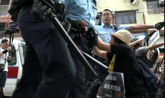 ▲一名母親跪下向警方求饒，卻被推開繼續爆打。（圖／截自香港電台視像新聞 RTHK VNEWS）