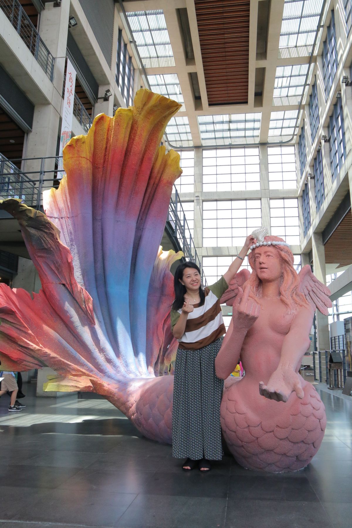 ▲新北市文化局長蔡佳芬把特製的陶瓷貝殼襄在藝術家游忠平作品《我愛超級美人魚》的頭飾上，象徵「2019夏日泥巴藝術季」活動正式開始。（圖／記者蔡琇惠攝，2019.07.16）