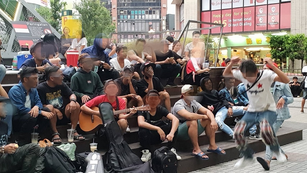 ▲數十名移工於東協廣場金字塔前席地而坐、自彈自唱，氣分歡愉（圖／記者鄧力軍攝, 2019.07.21）