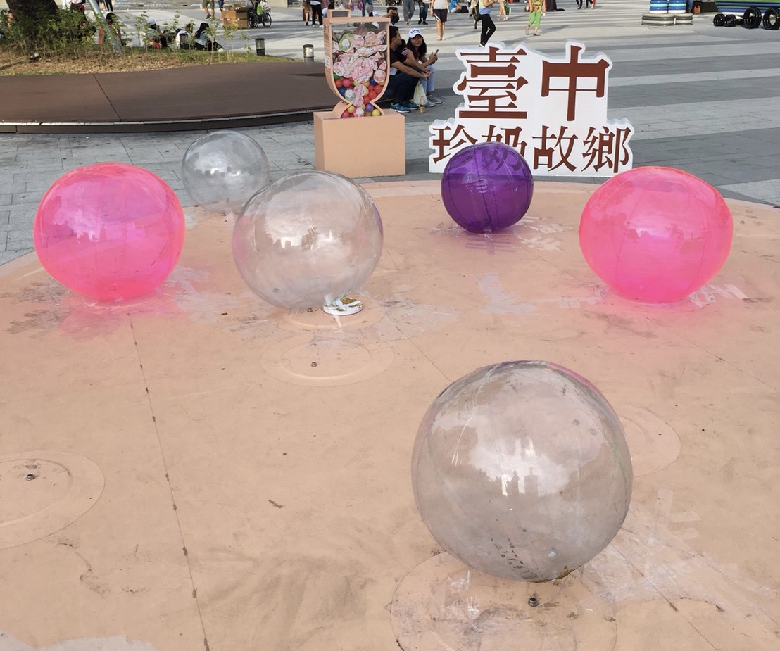 ▲在台中火車站前廣場展出珍珠奶茶意象的裝置藝術，珍珠造型的圓球漏氣消風。 (圖／江肇國提供2019.7.22)