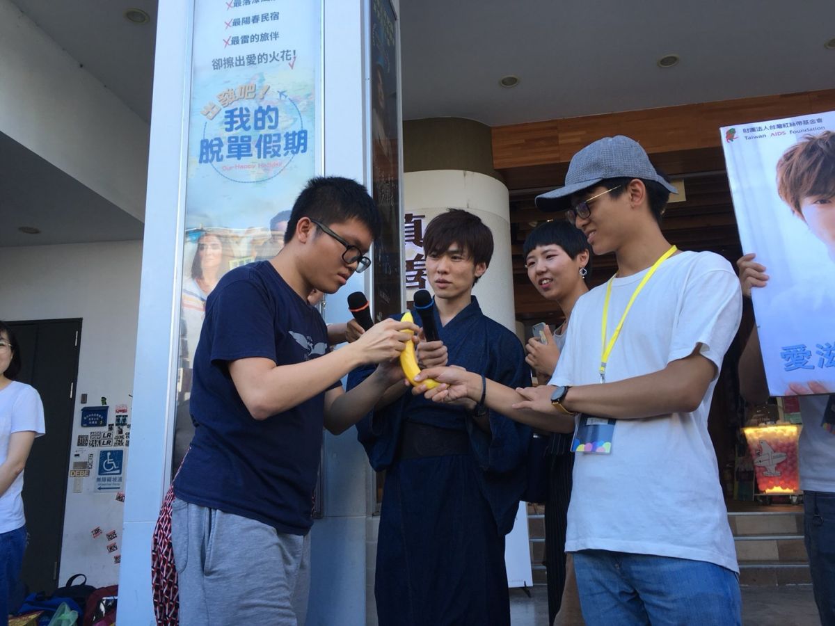 ▲鈴木一徹在街頭示範保險套使用。（圖／台灣紅絲帶基金會提供）