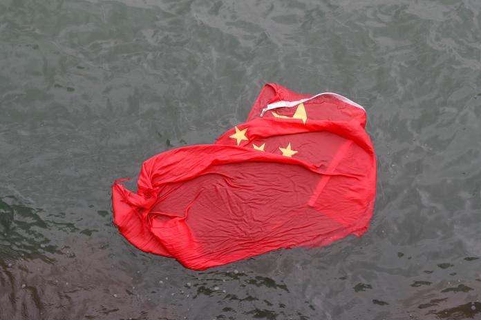 ▲香港旺角再遊行數名示威者降下海港城5支旗桿上的五星旗、丟入海中。（圖／美聯社／達志影像）