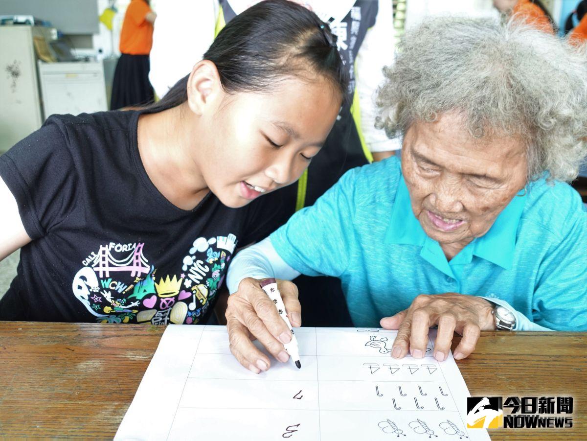 ▲全勤獎的84歲梁陳金晟阿嬤，終於有機會學識字，在99年次的陪考員協助下進行期末考。（圖／記者陳雅芳攝，2019.08.05）