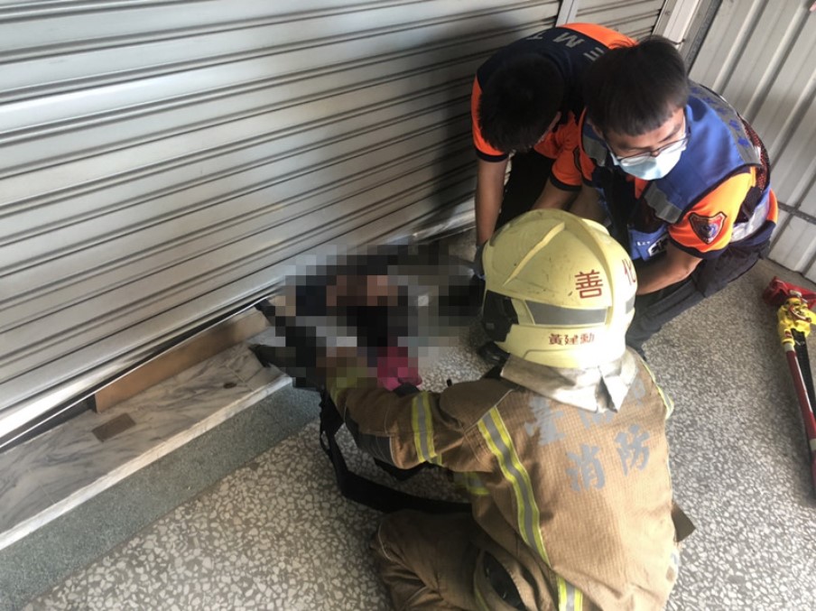 ▲楊姓婦人頭露出門外，疑遭鐵捲門壓頸窒息而亡。（圖／記者陳聖璋翻攝）