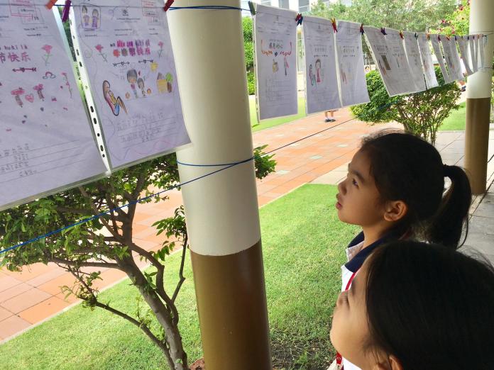 ▲泰國的學童專注地看著繪畫比賽的作品。（圖／台灣普力關懷協會提供）