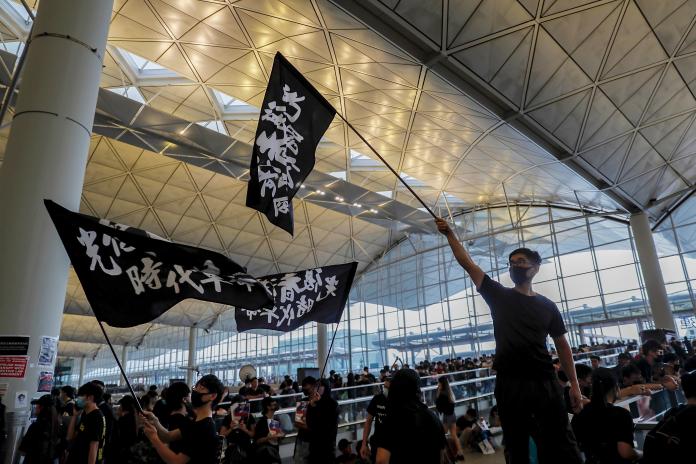 ▲昨（12）日下午許多「反送中」抗議民眾前進香港機場，大批「黑衣人」使得機場幾乎癱瘓，許多航班也因此停擺。（圖／達志影像／美聯社）