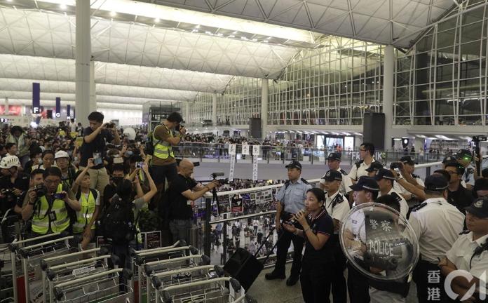▲香港警方衝入香港國際機場，一名男子被警員押走。（圖／翻攝香港01）