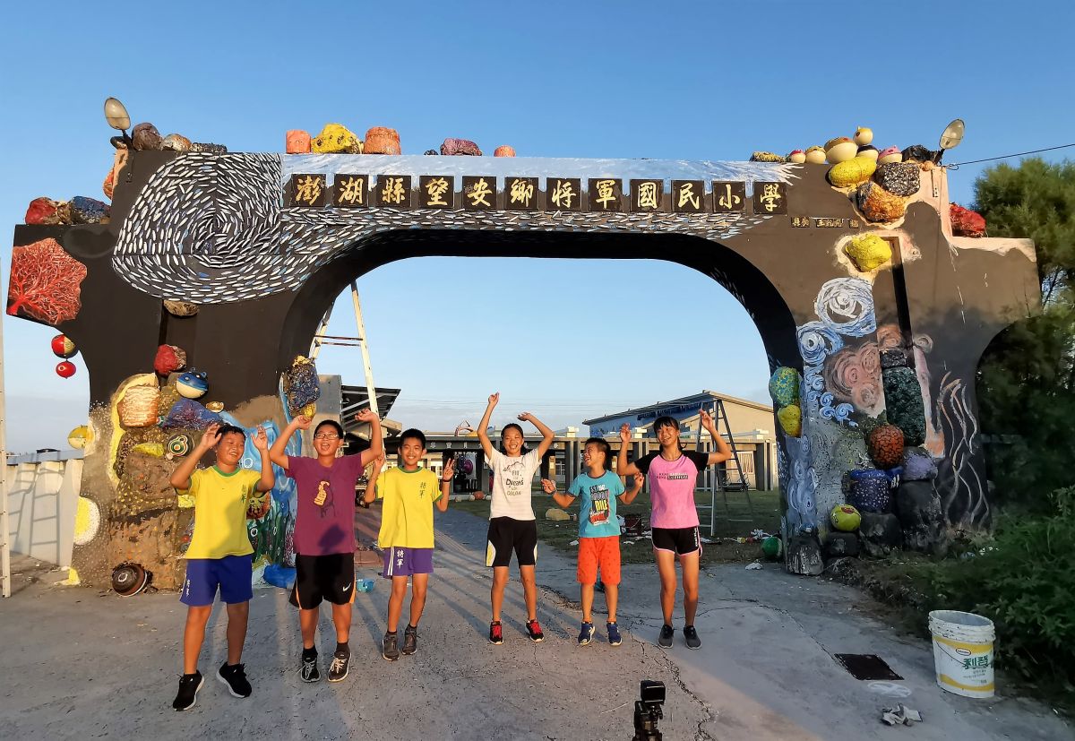 ▲在地藝術家吳成夫（小花)帶領學校孩子淨灘、撿海廢，經由共同創作與再利用，所改造的海洋風校門牌樓17日歡樂呈現在大家眼中。（圖／吳成夫提供，2019.08.17）