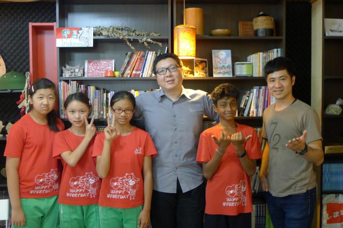 望見書間創辦人林周熙（右三），與建國國小學生參訪書店時合影。圖／望見書間提供