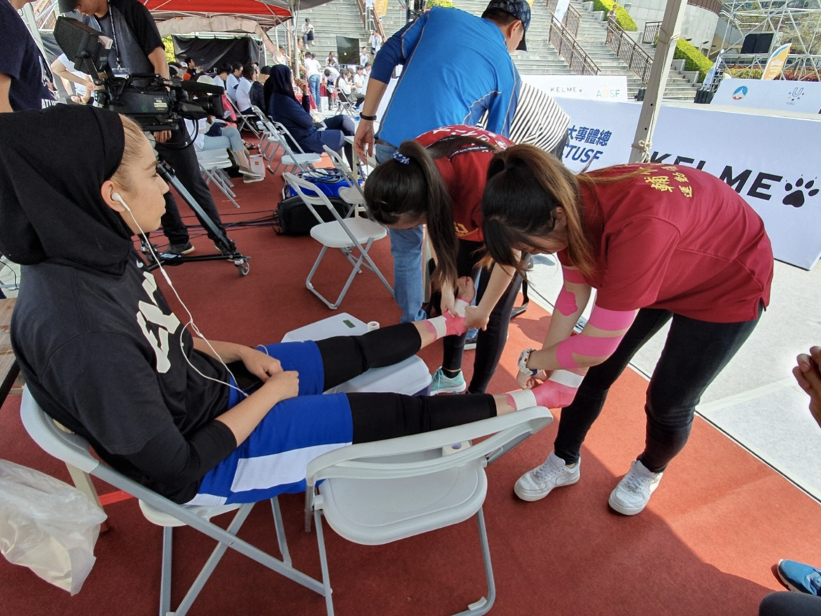輔大學生防護員在場邊協助選手運動放鬆。輔大防護隊_提供