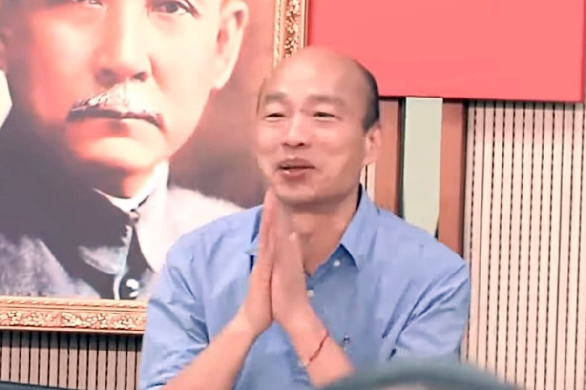 韓國瑜直到會議進行25分鐘之後，才快步走入會場，韓雙手合十朝在場人員鞠躬致歉。（圖 / 翻攝網路影片）
