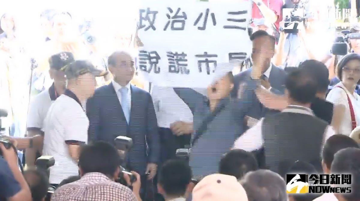 ▲台灣國辦公室主任陳峻涵在郭柯王三人合照時，高舉「政治小三、說謊市長」的標語抗議。（圖／丁上程攝, 2019.8.23）