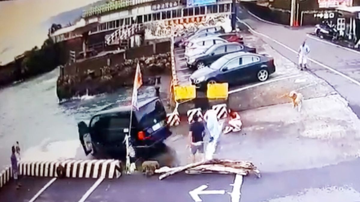 ▲一輛載滿9人的休旅車，25日下午疑因下坡道路濕滑轉彎不及，不慎衝入紅柴坑漁港內，全部平安獲救 。（圖／海巡署提供）