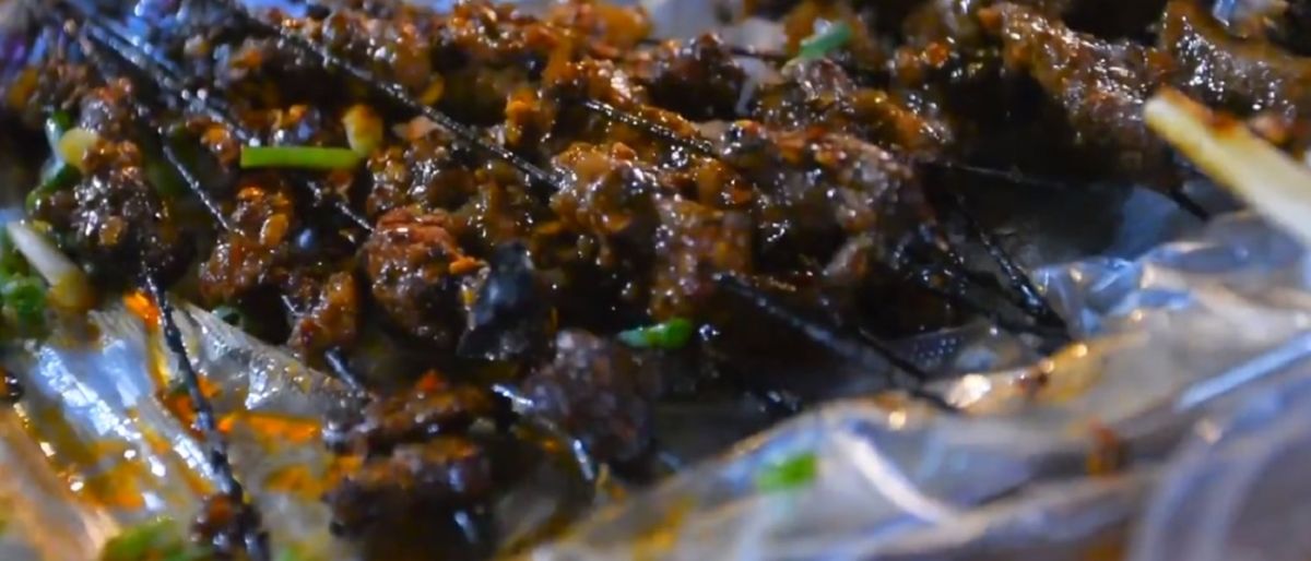 ▲大口吃肉大口喝酒真的是聚餐時少不了的行為，烤的酥脆的烤肉串一口咬下真的是非常美味，但若咬下的肉串式前一位客人吃過的，各位敢接受嗎？（圖／翻攝自影片）