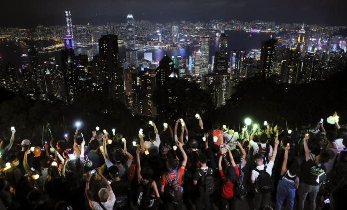 ▲13 日中秋夜，不少香港市民登上著名的獅子山、太平山等山頂，築成「人形光鏈」。（圖／美聯社／達志影像）