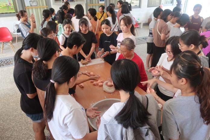 ▲志工媽媽教導外籍學生手作金門傳統紅龜粿。（圖／金門大學提供）