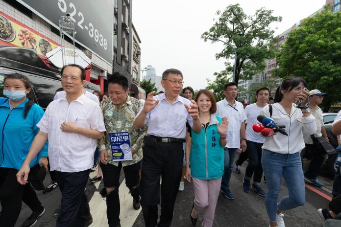 台北市長柯文哲下鄉走透透時，欲投入區域立委選戰的何景榮（拿書者）隨侍在側。