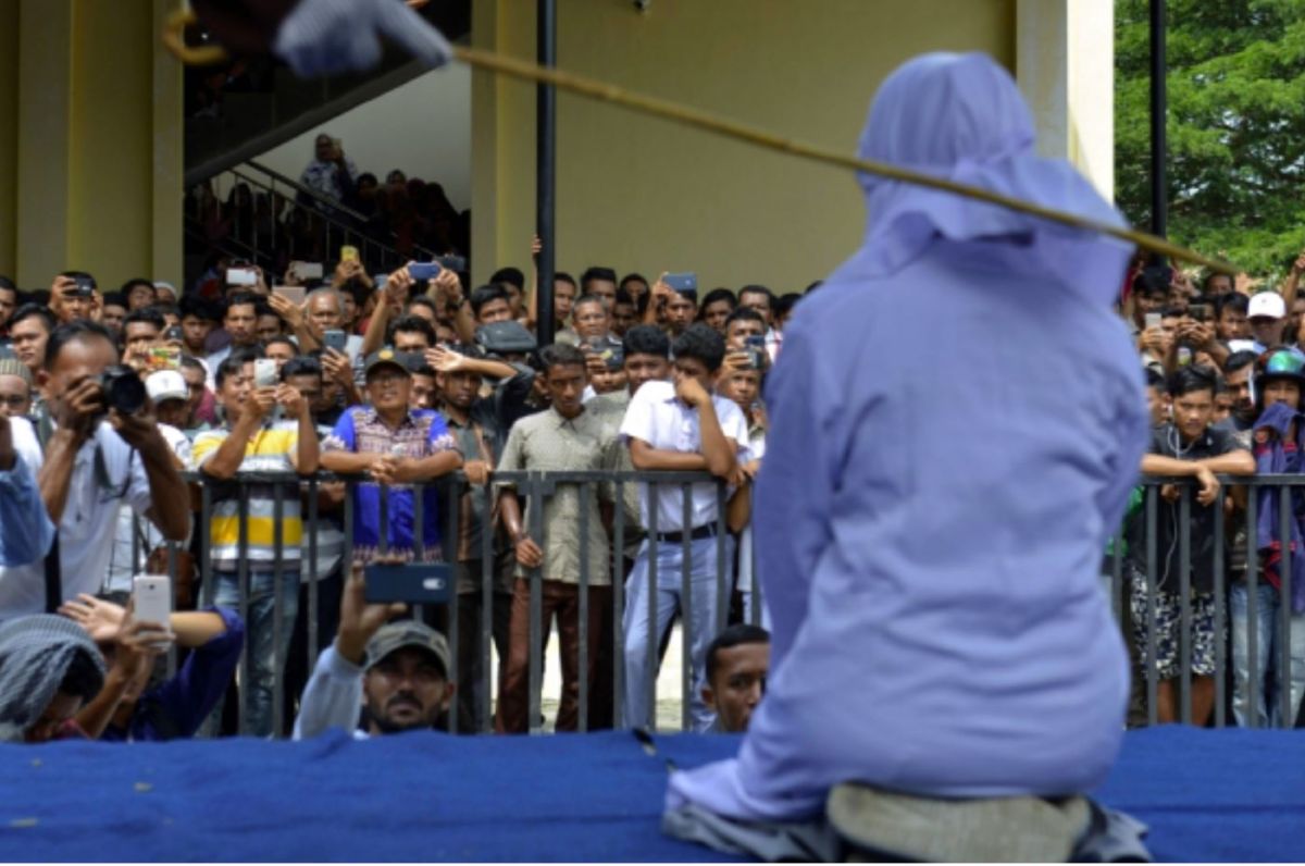 一名印尼女子遭到鞭打，因為被發現和男友擁抱。（圖／AFP）