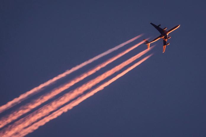 ▲飛機劃過天際時產生的飛機雲，是天空中另類的景緻。圖為 2017 年德國一架飛機於夕陽餘暉下，劃出飛機雲之資料照。（圖／美聯社／達志影像）