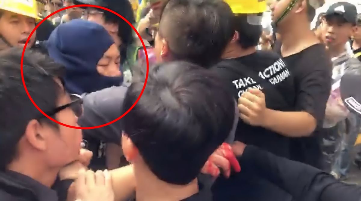 ▲黑衣男子戴頭套身穿「反送中」字樣服飾，對何韻詩潑漆後遭工作人員包圍。（圖／民眾提供）