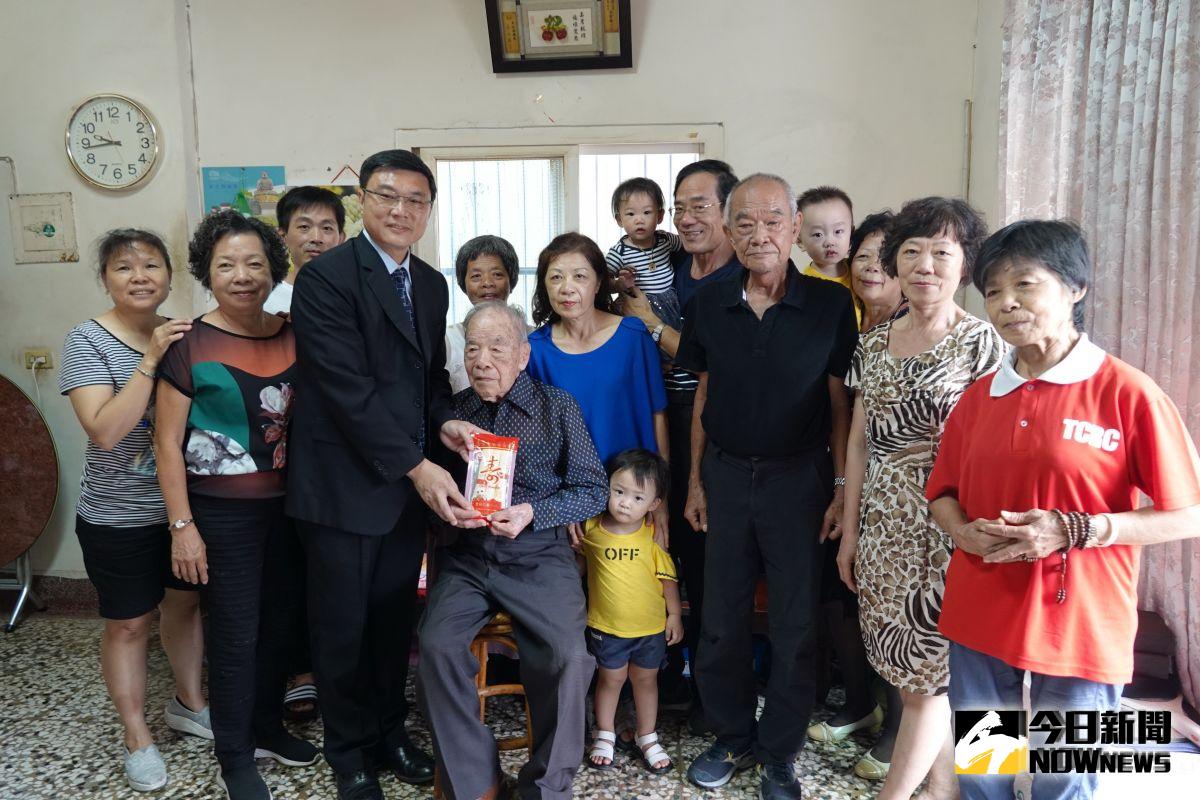 ▲鹿港鎮長許志宏訪視102歲人瑞詹金環，贈送百歲人瑞每人一萬元紅包及金鎖片等禮物，陪著老先生聊天。（圖／記者陳雅芳攝，2019.09.30）