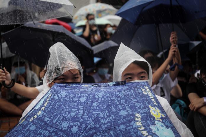▲香港反送中延燒,中學生2日在中環愛丁堡廣場發起罷課集會,要求港府回應反條例「5大訴求」,儘管雨越下越大,仍澆不熄學生熱情。中央社記者吳家昇攝108年9月2日