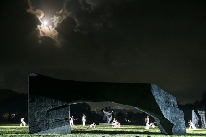 ▲朱銘美術館開館滿20週年,14日在美術館舉行20週年館慶活動,晚間則邀請雲門舞集演出,舞者在銅雕大型太極拱門旁舞「水月」,中秋節過後的月亮圓又亮,時而搭配著音樂及舞姿露出光亮,時而又像害羞的月娘遮住臉龐。中央社記者謝佳璋攝108年9月14日