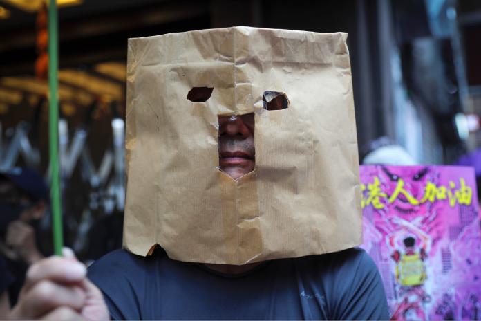 ▲大批香港示威人士戴上面罩、口罩及自製面具，參與「反緊急法」遊行。（圖／美聯社／達志影像）