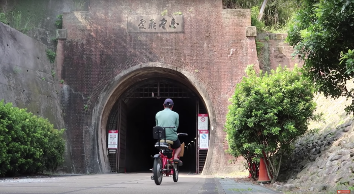 草嶺隧道，過去曾經是台北與東部地區的交通要道，現在成為觀光勝地，艾琳騎著腳踏車通過舊草嶺隧道，感受古今之間的連結。（圖片截自YouTube: Falling in love with Taiwan）
