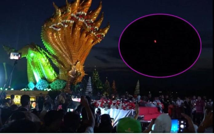 人潮擠在岸邊，屏息等待，當紅色的小球從河流中冉冉升起，群眾爆出歡呼，歡慶泰國廊開府（Nong Khai）「娜迦吐龍珠（Naga Fireballs）」火球節。（圖／泰國世界日報）