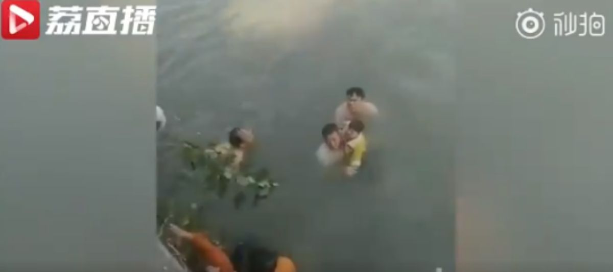 ▲大陸江蘇 1 名女子，日前因誤把油門當剎車，連人帶車掉進河裡，車上當時還載有小孩，所幸有熱心路人救援。（圖／截自視頻片段）
