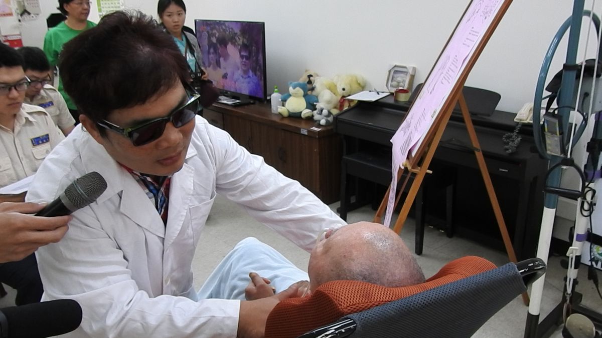 ▲視障歌手張振華用精湛的按摩技巧，替植物人按摩並解釋穴道的奧秘。（圖／記者蘇榮泉攝，2019.10.31）