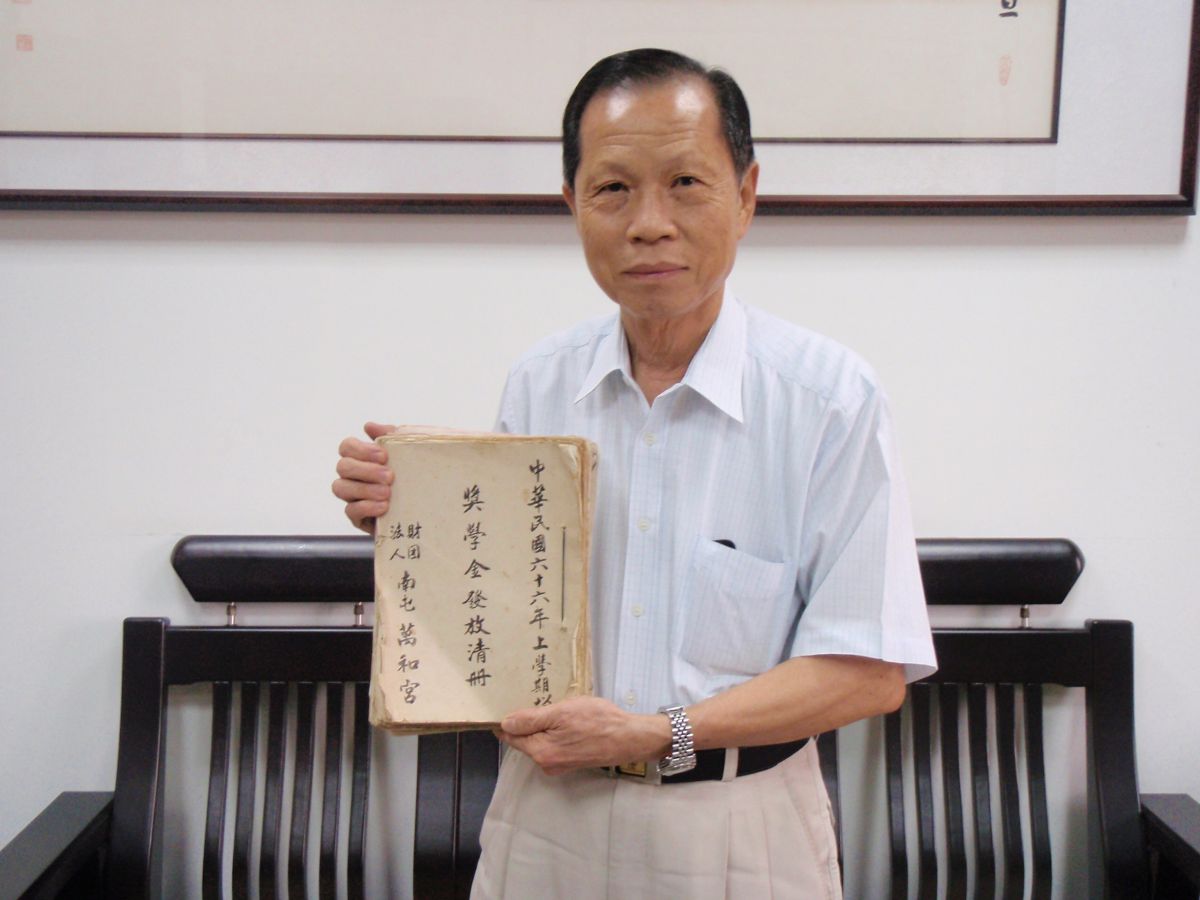 ▲萬和宮董事長蕭清杰展示收藏珍寶─40多年前第一屆發放獎學金名冊，今年邁入第42年。（圖／萬和宮提供）