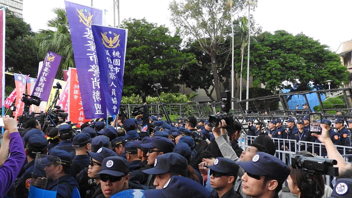 近千名退休警察12日下午齊聚行政院前，仿效太陽花攻佔行政院模式，與警方發生劇烈推擠。（圖 / 記者陳弘志攝）