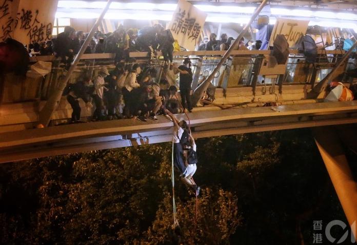 ▲理大受困示威者嘗試利用垂吊的方式離開。（圖／翻攝自《香港 01 》）
