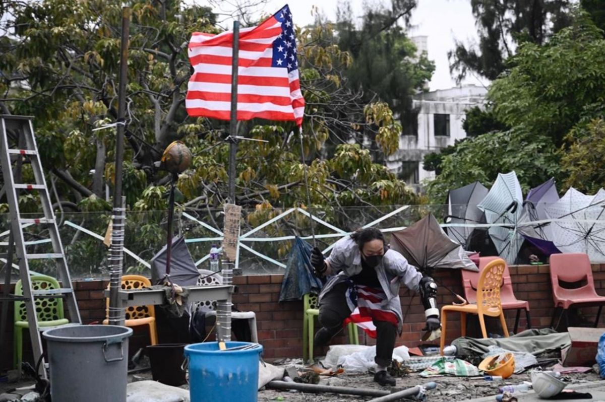 ▲美國參議院在港台時間 20 日清晨，通過《香港人權與民主法案》的參議院版本，同時也通過限制非致命武器出口的《保護香港法案》。有留守理工大學的示威者得知消息後，在校園內揮動美國國旗。（圖／翻攝自立場新聞）