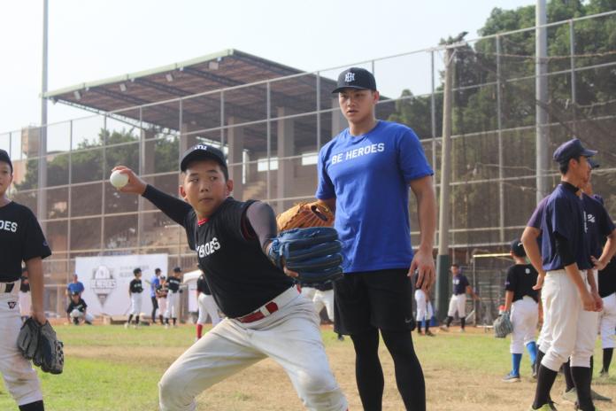 投手江少慶指導小學員投球。（圖／記者黃彥迪攝）