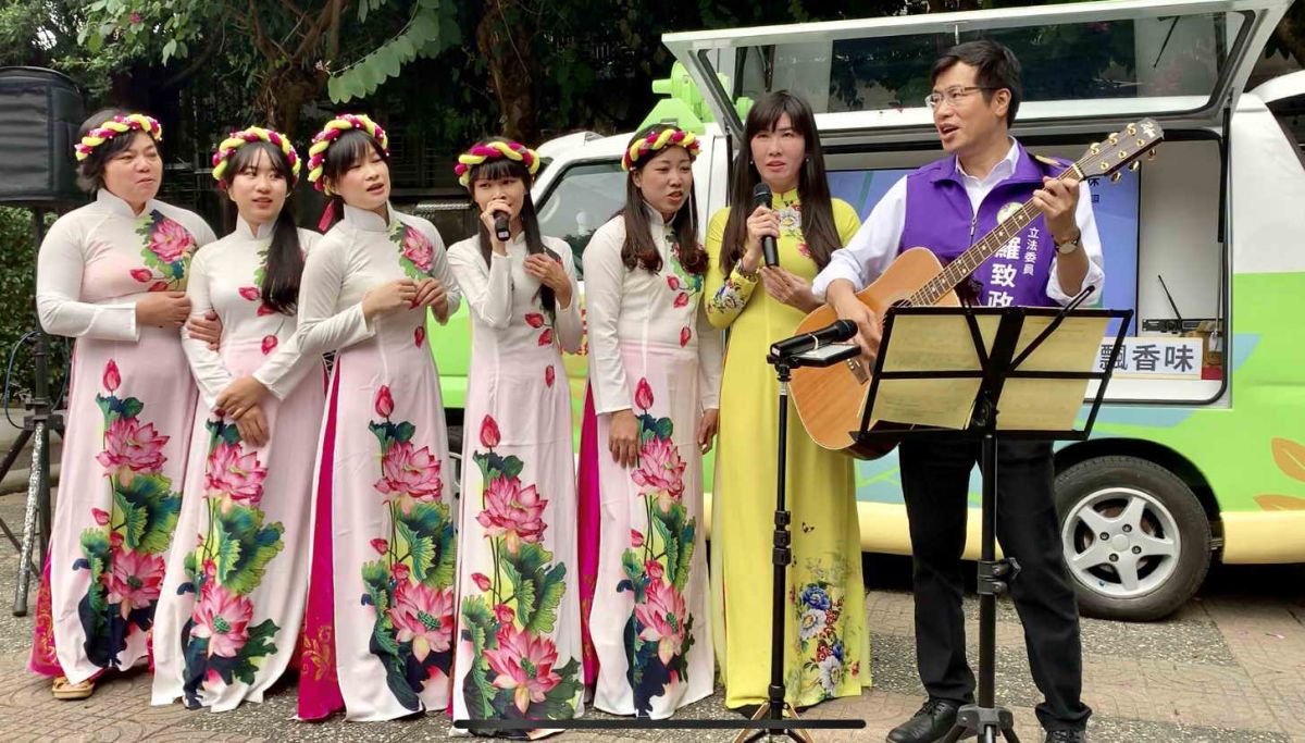 ▲立委羅致政彈奏吉他，與新住民一起演唱中文和越語版的「月亮代表我的心」。（圖／立委羅致政服務處提供）