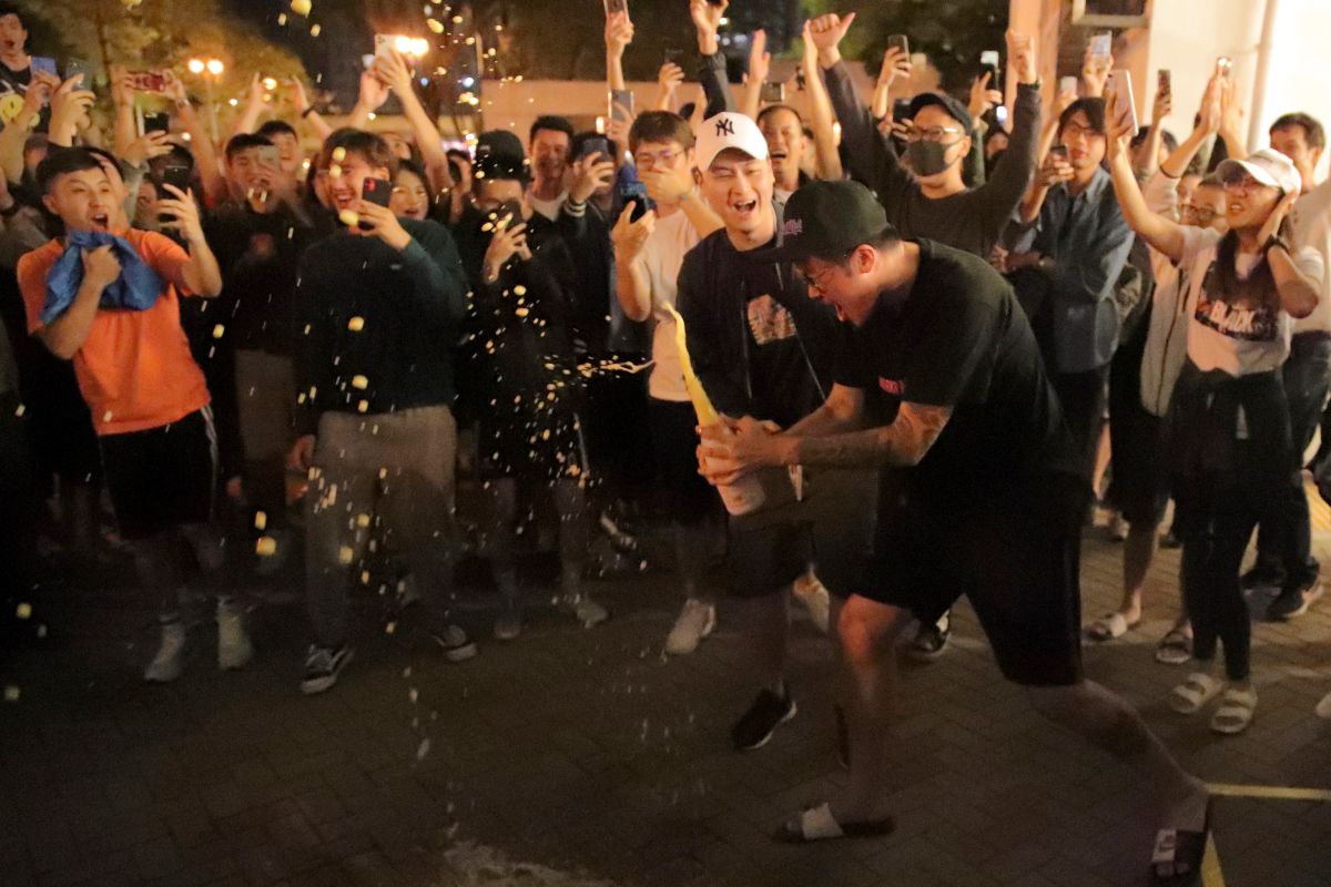 ▲有香港市民在建制派議員何君堯落敗後，興奮的開香檳慶祝。（圖／美聯社／達志影像）