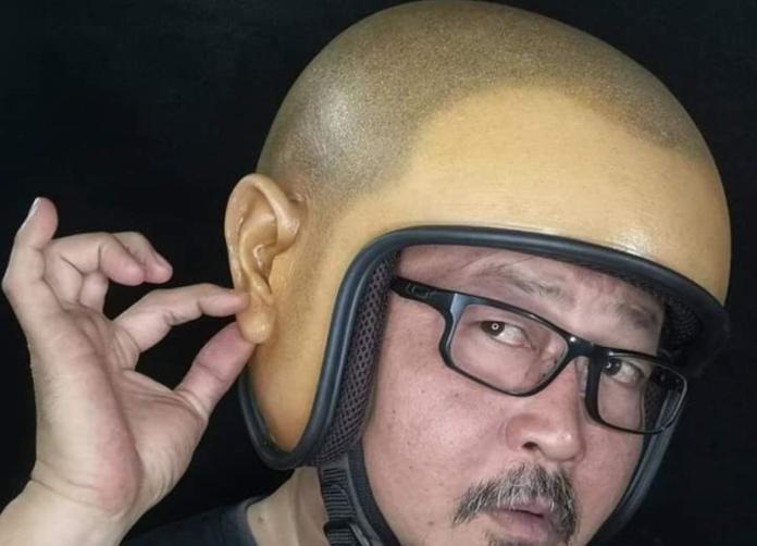 泰國北部清邁的藝術家設計了一款「光頭安全帽」，戴在頭上，快速飛馳過馬路時假以亂真。（圖／翻攝自臉書）