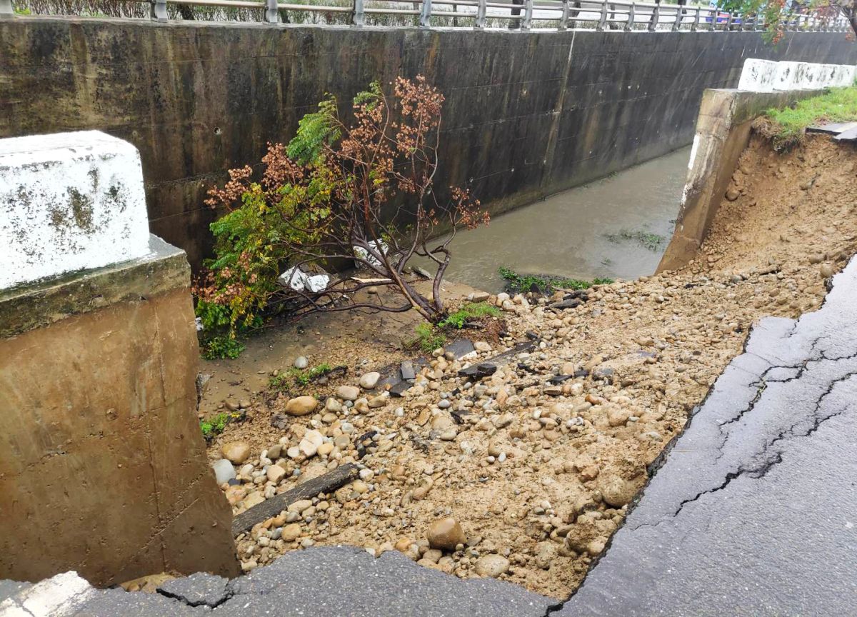 ▲員警獲報到達現場後，發現路面破了一個大洞，溪旁邊坡的一棵樹木也傾倒在溪水中。（圖／蘆竹分局提供）