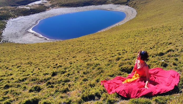 一對夫婦齊心協力，攀登3310公尺抵達台東的嘉明湖，妻子花露露旋即換上深紅色晚禮服，和「天使的眼淚」嘉明湖拍下動人的倩影。（圖／花露露女士提供）