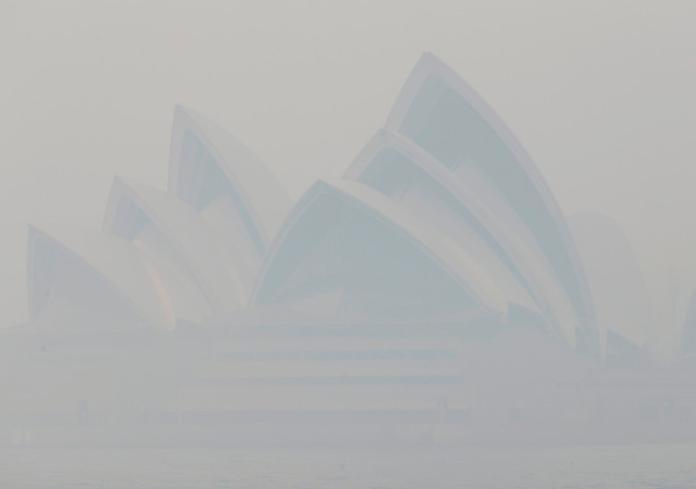 ▲雪梨歌劇院被野火燃燒的煙霧遮蓋，幾乎看不見該建築物。（圖／美聯社／達志影像）