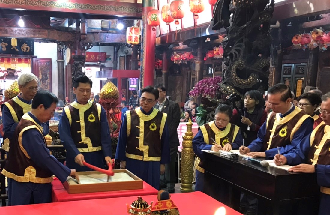 ▲扶鸞是透過神明傳遞訊息，圖為鸞生在沙盤藉由鸞筆寫出鸞文，一旁眾人逐字記錄。（圖／金武鳳攝，2019.12.21)