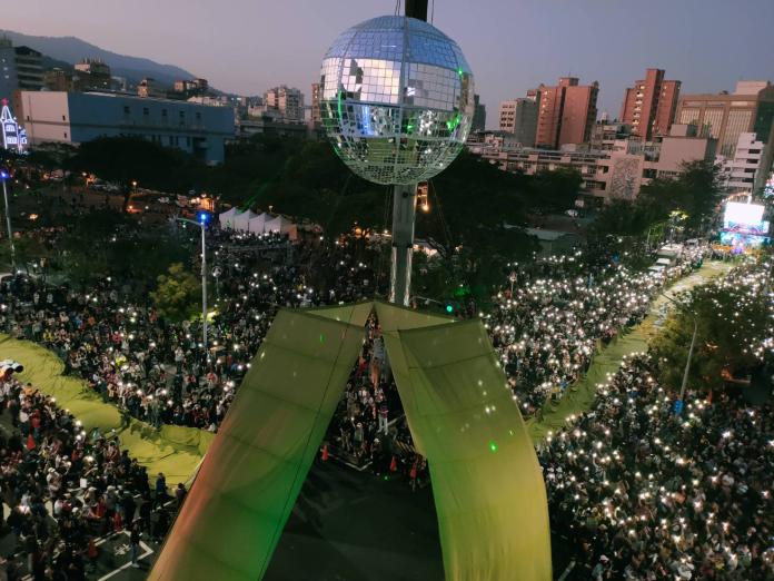 ▲「Wecare台灣大遊行」，以高懸直徑5公尺超大鏡球，群眾以手持發光器材形成燈海，營造「綠色聖誕、平安台灣」的溫馨。圖／Wecare高雄提供)